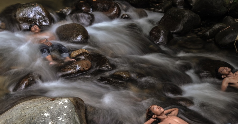 06.out.2015 - Jovens se refrescam na água de rio, em Hulu Langat, na Malásia
