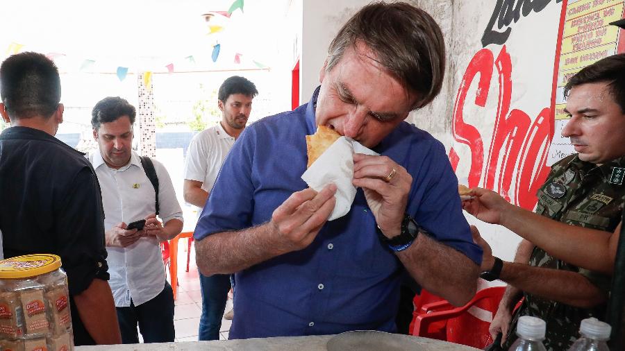 Presidente Jair Bolsonaro come pastel durante visita ao comércio local de Aracaju (SE) -  Alan Santos/PR