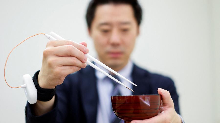 Funcionário usa hashis que prometem melhorar sabor da comida usando estimulação elétrica - Issei Kato/Reuters