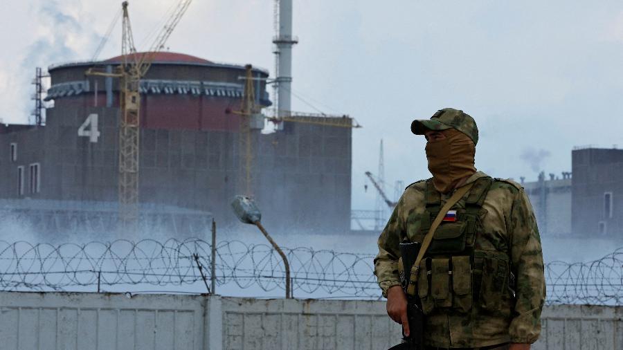 4.ago.2022 - Militar com uma bandeira russa em seu uniforme monta guarda perto da Usina Nuclear de Zaporizhzhia  - REUTERS/Alexander Ermochenko/Foto de Arquivo
