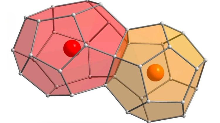 Diagrama ilustrando a estrutura do clatrato, com esferas cinzentas representando o silício e laranja e vermelho representando os sítios de cálcio