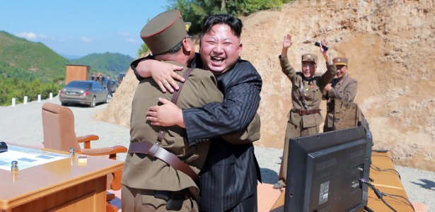 Imagem divulgada pela agência oficial norte-coreana KCNA mostra Kim Jong-un (de terno) comemorando o sucesso do teste intercontinental em um local não divulgado - KCNA via AFP