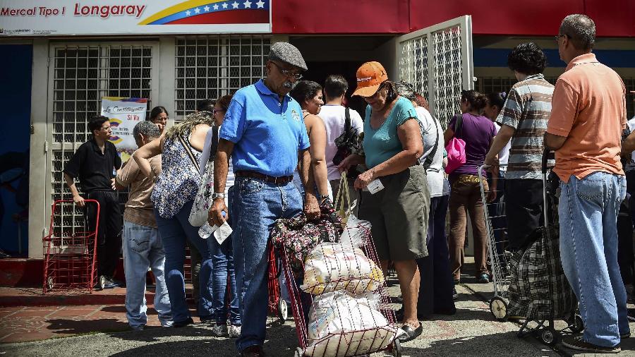 16.ago.2017 - Homem empurra carrinho com alimentos distribuídos em um Clap, em Caracas, Venezuela - Ronald Schemidt/ AFP