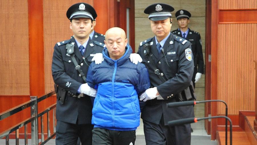 9.fev.2015 - O serial killer Zhao Zhihong é escoltado para julgamento de assassinato, estupro, roubo e furto  - Xinhua