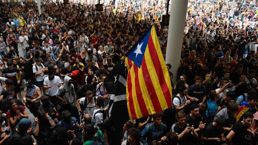 Multidão com bandeira independentista toma acesso do aeroporto de El Prat, em Barcelona - Josep Lago / AFP