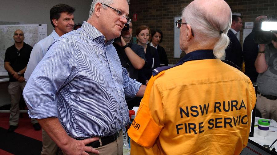 O primeiro-ministro da Austrália, Scott Morrison, visita uma das sedes dos bombeiros em Sydney, após ser criticados por viajar enquanto o pais enfrenta graves incêndios florestais - AAP Image