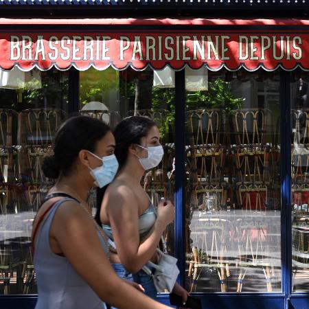 30.mai.2020 - Mulheres com máscaras passam em frente a um restaurante fechado em Paris - Bertrand Guay - 30.mai.2020/AFP