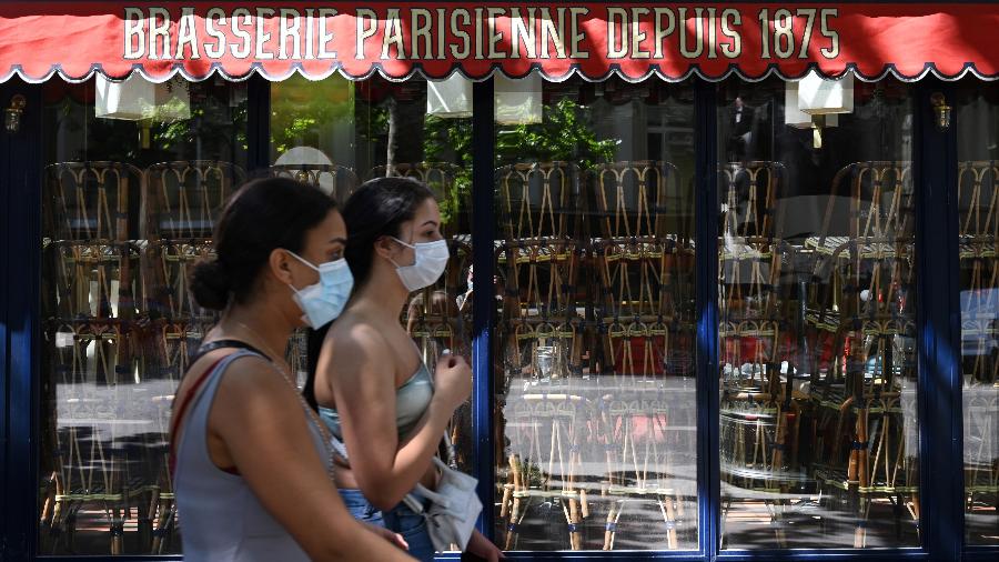 Mulheres com máscaras passam em frente a um restaurante fechado em Paris - Bertrand Guay - 30.mai.2020/AFP