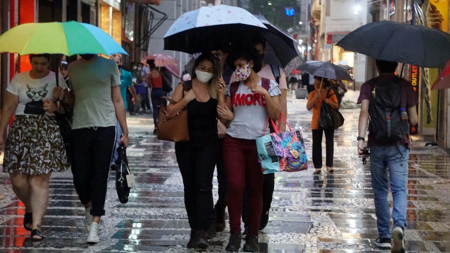 Pedestres se protegem da chuva no centro de São Paulo; toda a cidade ficou em estado de atenção - Cris Fraga/Estadão Conteúdo