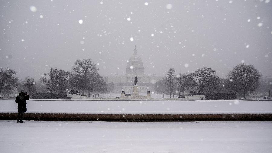 16.jan.2022 - Visitante tirando foto da capital norte-americana, Washington DC, em meio à tempestade - Stefani Reynolds/AFP