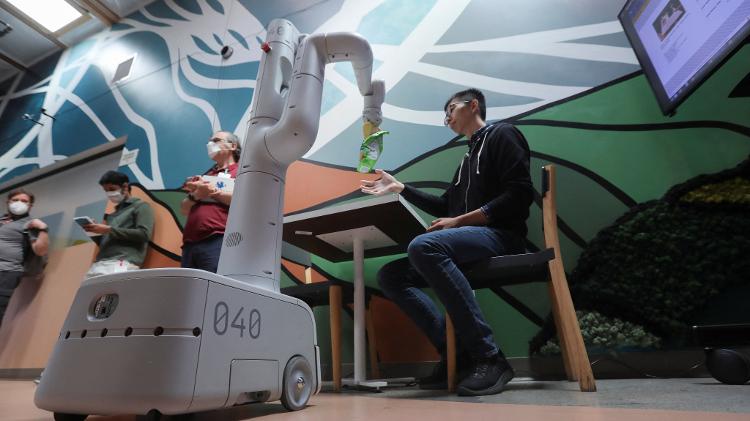 Robô do Google se move até o pesquisador Fei Xia para entregar um pacote de batata frita - Nathan Frandino/Reuters - Nathan Frandino/Reuters