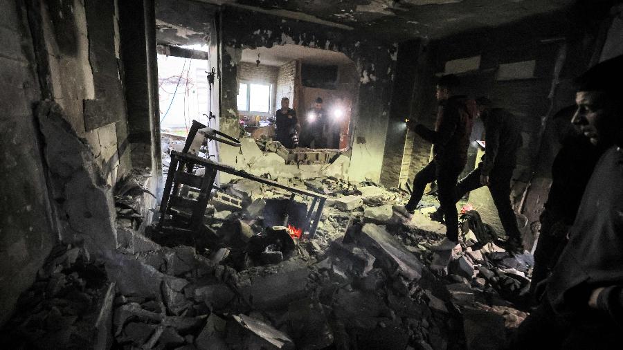 Palestinos inspecionam escombros de prédio atingido por um míssil israelita - Jaafar Ashtiyeh/AFP