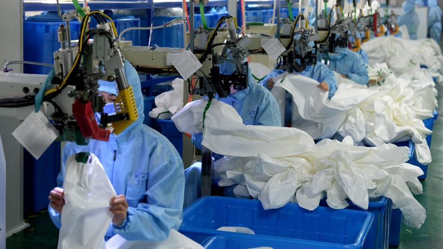 Trabalhadores fabricam roupas de proteção em fábrica da farmacêutica Hefei, em Anhui, na China - Xinhua/Huang Bohan