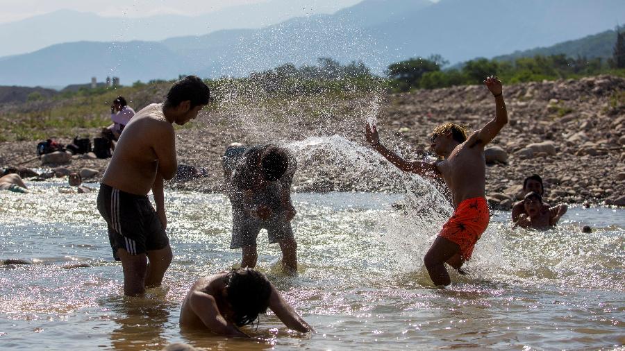 Crianças se refrescam am lago em cidade argentina - REUTERS