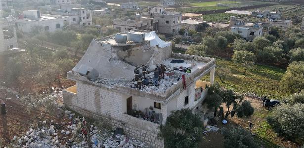 Equipes de saúde e sírios se reúnem em edifício destruído após ataque noturno dos EUA contra membros do grupo extremista Estado Islâmico