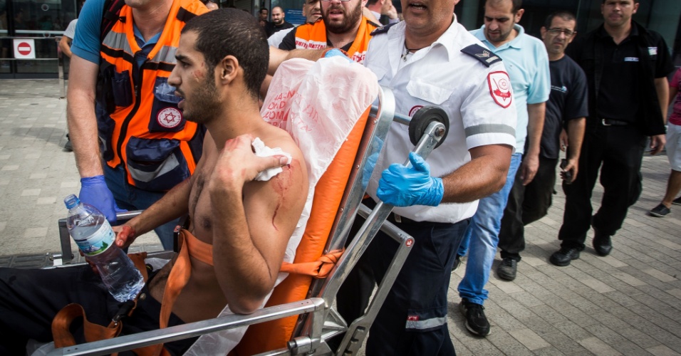 13.out.2015 - O judeu Uri Rezken é socorrido após ser esfaqueado em Kiryat Ata, no subúrbio de Haifa, em Israel. Ele foi atacado por outro judeu que o confundiu com um árabe