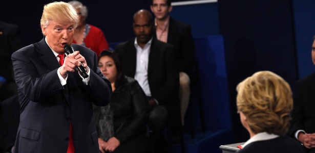 O candidato republicano Donald Trump e a democrata Hillary Clinton (à direita, de costas) participam do segundo debate presidencial nos EUA - Saul Loeb/ AFP