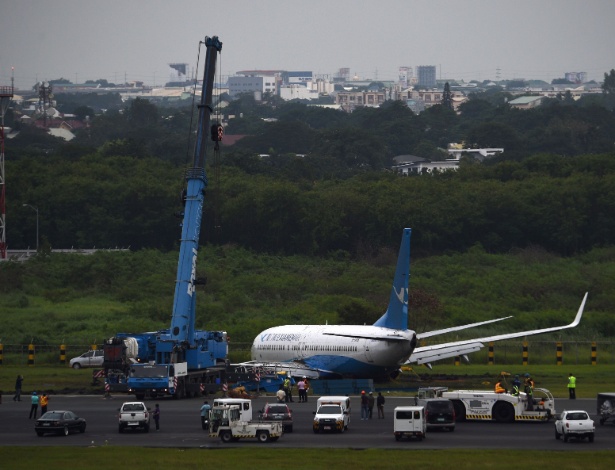 Guindaste tenta retirar aeronave de campo encharcado após acidente nas Filipinas; avião saiu da pista durante o pouso - Ted Aljbe/AFP