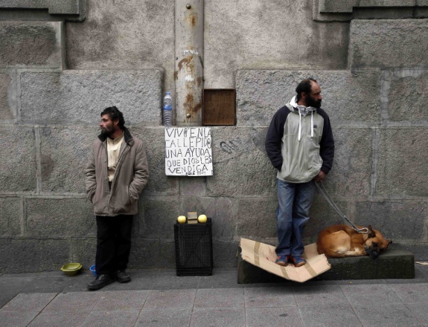 "Eu moro na rua. Estou pedindo ajuda. Deus te abençoe", diz o cartaz de moradores de rua, em Madri - Susana Vera/Reuters