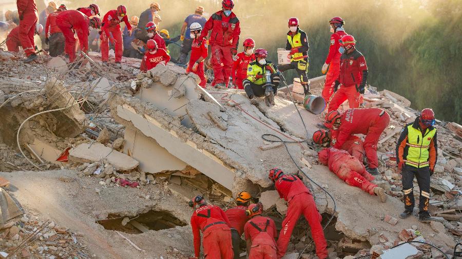 Equipe de resgate busca sobreviventes nos escombros de um prédio que desmoronou na região de Bayrakli, após um forte terremoto atingir a costa oeste da Turquia e parte da Grécia - Yasin Akgul/AFP