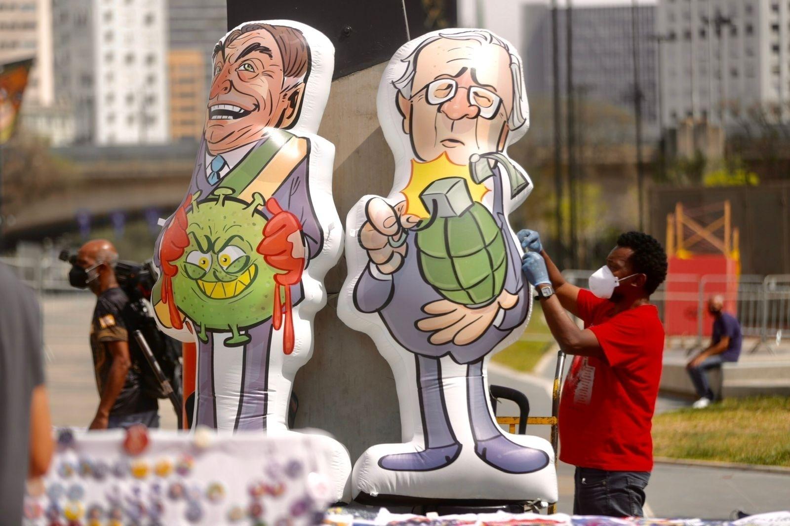 7.set.2021 - Homem ajusta bonecos do presidente Jair Bolsonaro (sem partido) e do ministro da Economia, Paulo Guedes,  para protesto contra o governo Bolsonaro, realizado no Vale do Anhangabaú, em São Paulo - Ricardo Matsukawa/UOL