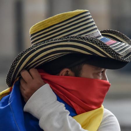 Homem protege o rosto na Colômbia durante a pandemia do novo coronavírus - Guillermo Legaria Schweizer/Getty Images