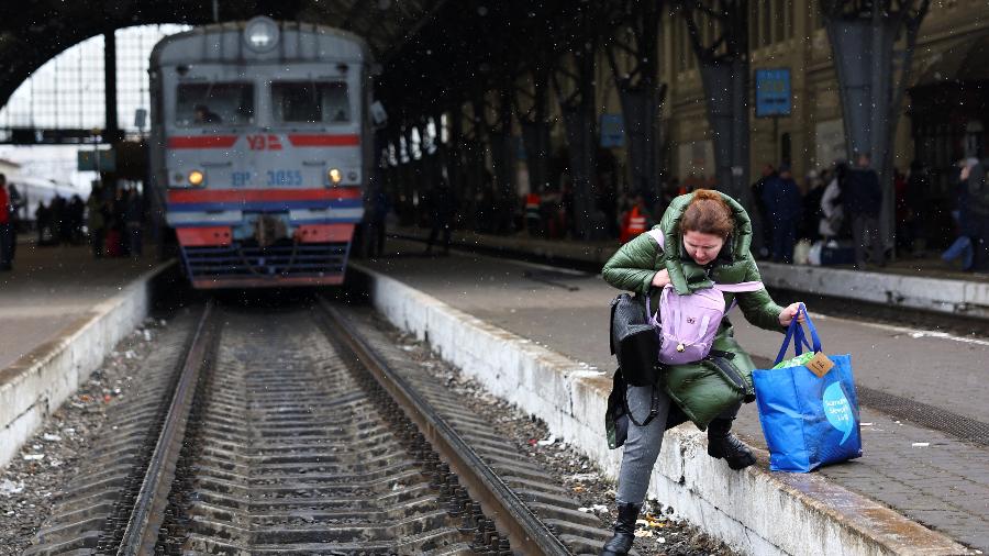 5.mar.2022 - Uma mulher atravessa os trilhos do trem enquanto procura o trem que vai para a Polônia, enquanto refugiados fogem da invasão russa da Ucrânia, na estação de trem em Lviv, na Ucrânia. - KAI PFAFFENBACH/REUTERS