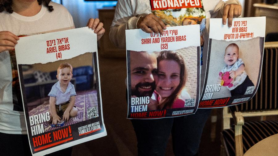 Manifestantes pedem soltura de reféns do Hamas em Genebra, na Suíça; à esquerda, o cartaz com a foto do bebê Kfir Bibas, de 10 meses