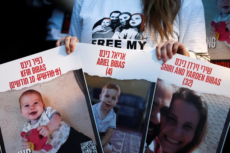 28.nov.2023 - Um manifestante segura cartazes pedindo a libertação dos reféns de Shiri Bibas, 32, e seus filhos Kfir Bibas, 10 meses, e Ariel, 4 