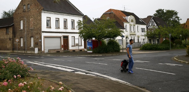 O refugiado albanês Alban, 27, caminha pelas ruas vazias de Manheim, na Alemanha; cerca de 100 refugiados obtiveram abrigo temporário nas casas abandonadas na cidade - Kai Pfaffenbach/Reuters