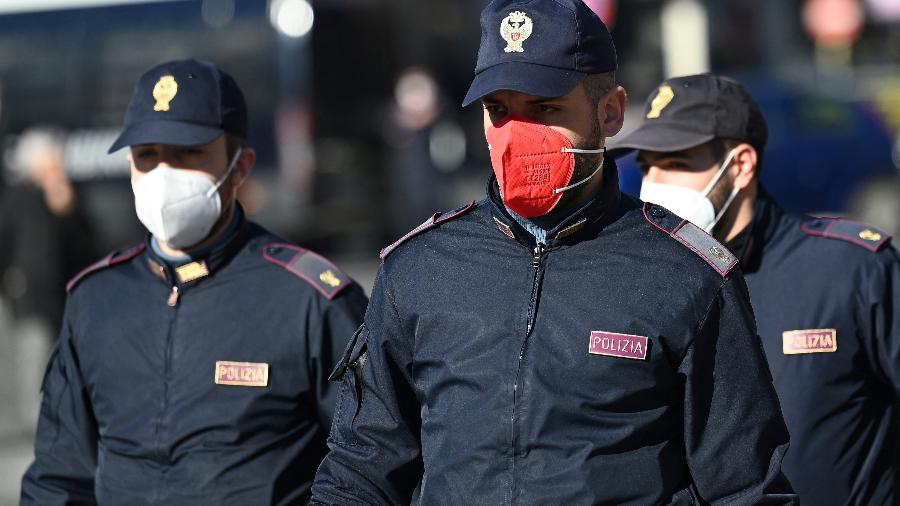 Policiais da força policial Polizia di Stato, um deles usando uma máscara facial colorida, patrulham o centro de Roma - Vincenzo PINTO / AFP