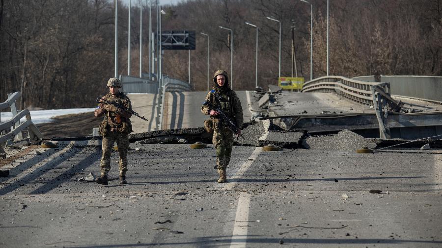 20.mar.22 - Soldados ucranianos caminham ao lado de uma ponte destruída entre Trostianets e Okhtyrka - UKRAINIAN GROUND FORCES/via REUTERS