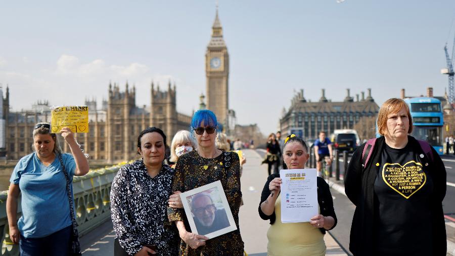 23.mar.2022 - Parentes de vítimas da covid-19 fazem um minuto de silêncio na Westminster Bridge, em Londres - Tolga Akmen/AFP