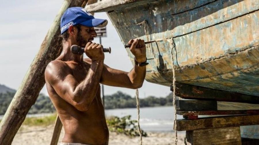 Wladimir, pescador artesanal de Ubatuba (SP), calafetando seu barco - Guilherme Rodrigues/Divulgação 