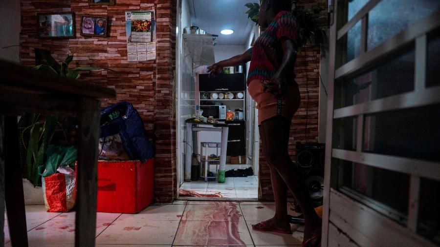 Mulher mostra cena do crime onde suposto traficante de drogas foi morto em operação no Jacarezinho, Rio de Janeiro, em 6 de maio de 2021  - Mauro Pimentel/AFP
