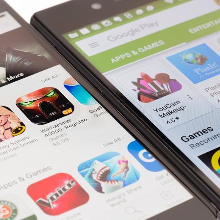 Detalhe de celulares exibindo a App Store (da Apple) e a Play Store (do Google)