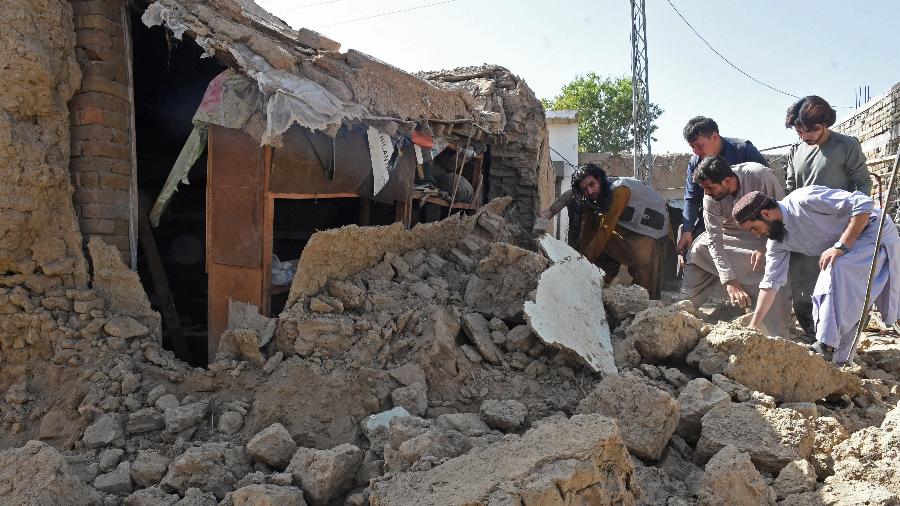 Moradores removem os destroços de suas casas danificadas após o terremoto no remoto distrito montanhoso de Harnai  - BANARAS KHAN / AFP