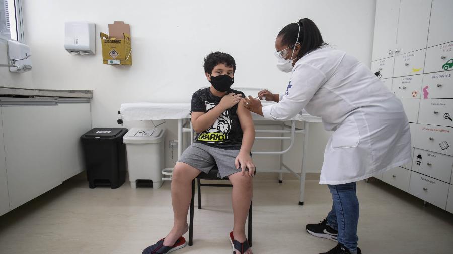 Garoto de 9 anos toma a primeira dose da vacina infantil da Pfizer contra a covid-19 na UBS Jardim Aeroporto, na zona sul de São Paulo -  FELIPE RAU/ESTADÃO CONTEÚDO