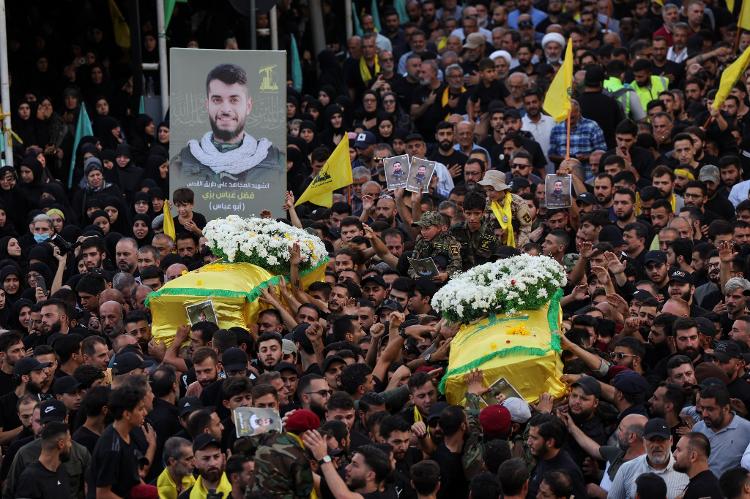 Libaneses carregam os caixões dos membros do Hezbollah mortos após explosão de pagers e walkie-talkies em 19 de setembro