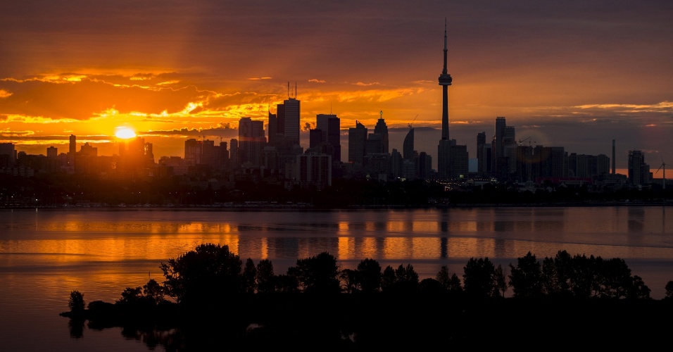 04.ago.2015 - O sol nasce no horizonte da cidade de Toronto, no Canadá
