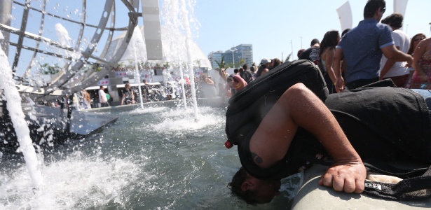 24.set.2015 - Fã não suporta o calor e coloca a cabeça em fonte para se refrescar na Cidade do Rock após a abertura dos portões para o 4º dia do festival Rock in Rio, na Barra da Tijuca, zona oeste do Rio de Janeiro. A previsão é que os termômetros marquem até 38ºC nesta quinta-feira - Fábio Motta/ Estadão Conteúdo - Fábio Motta/ Estadão Conteúdo
