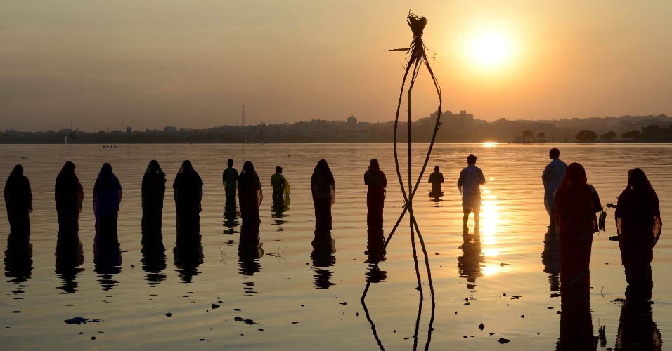 17.nov.2015 - Devotos hindus oferecem orações ao sol durante o festival Chhath nas margens do lago Hussain Sagar, em Hyderabad, na Índia