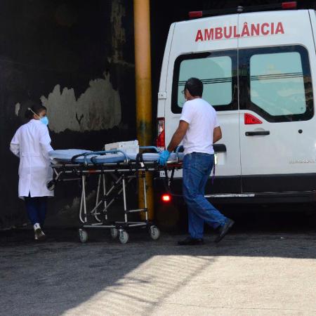 Profissionais de saúde carregam maca em frente a ambulância em hospital no Rio - Marcos Vidal/Futura Press/Estadão Conteúdo