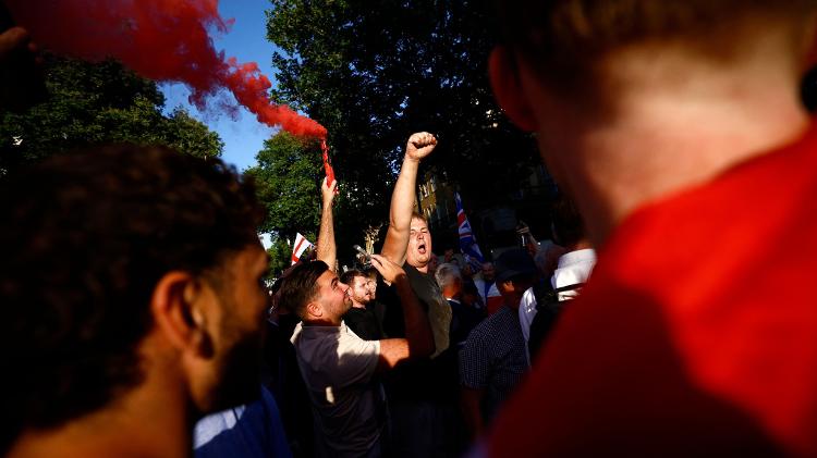 Um manifestante acende sinalizador durante a manifestação 'Enough is Enough' no centro de Londres, realizada em reação à resposta do governo ao esfaqueamento de crianças em Southport 