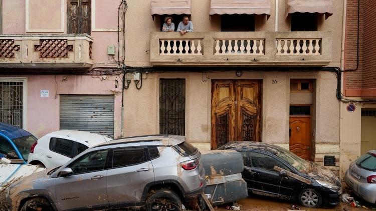 31.out.2024 - Moradores olham da sacada para carros empilhados após enchentes em La Torre, ao sul de Valência