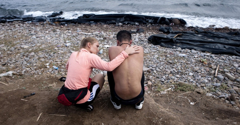 23.set.2015 - Voluntária tenta consolar um refugiado na praia de Sykamia, a oeste do porto de Mitilene, na ilha grega de Lesbos, depois dele atravessar o mar Egeu, da Turquia até o país