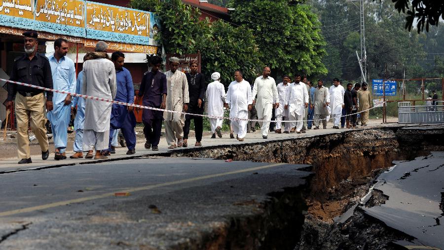 25.set.2019 - Pessoas caminham em via que foi danificada por terremoto no Paquistão