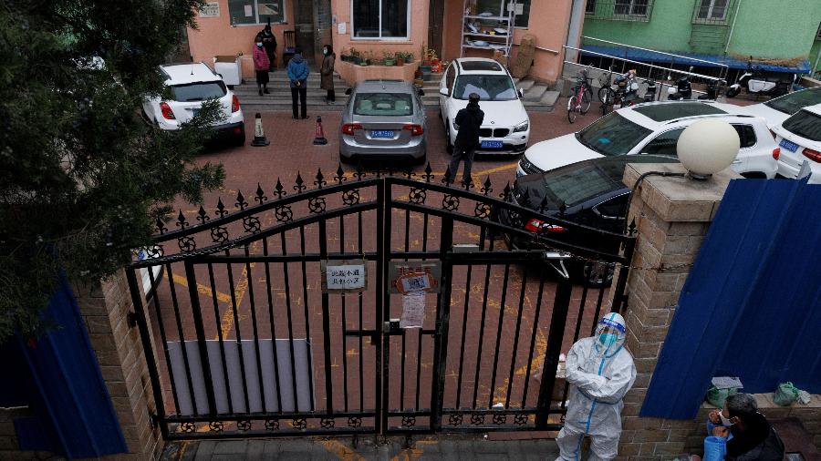 18.nov.22 - Um trabalhador de prevenção de pandemia em um traje de proteção vigia um complexo residencial depois que ele foi fechado enquanto os surtos de doença por coronavírus (COVID-19) continuam em Pequim - THOMAS PETER/REUTERS