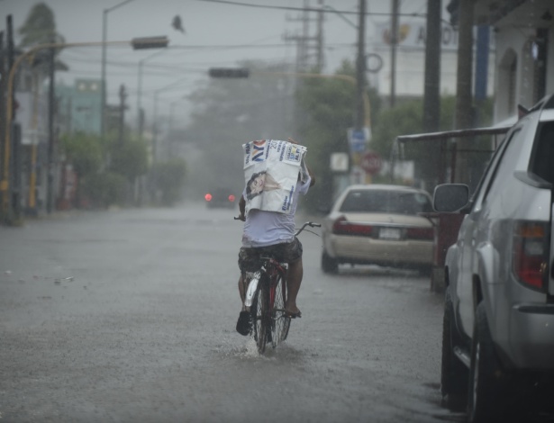 23.out.2018 - Morador anda de bicicleta por uma estrada enquanto o furacão Willa chega a Escuinapa, no México - ALFREDO ESTRELLA/AFP