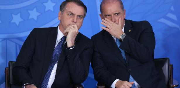 O Presidente Jair Bolsonaro conversa com o ministro da Casa Civil Onyx Lorenzoni durante solenidade de Lançamento de Linha de Crédito do BNDES para Organizações Filantrópicas, no Palácio do Planalto